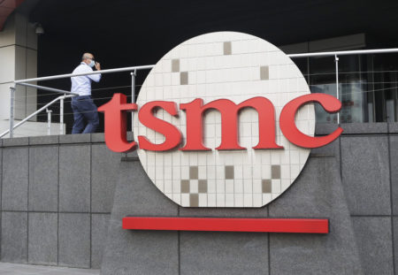 FILE - A person walks into the Taiwan Semiconductor Manufacturing Co., Ltd. (TSMC) headquarters in Hsinchu, Taiwan on Oct. 20, 2021. Taiwan Semiconductor Manufacturing Co., the biggest contract manufacturer of processor chips for smartphones and other products, said Thursday, Oct. 13, 2022, quarterly profit rose 79.7% over a year earlier to $8.8 billion amid surging demand. (AP Photo/Chiang Ying-ying, File)