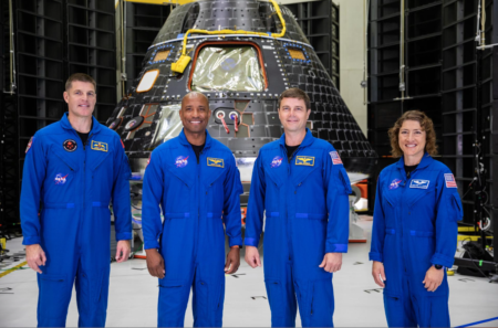 Artemis II crew members, shown inside the Neil Armstrong Operations and Checkout Building at NASA’s Kennedy Space Center in Florida, stand in front of their Orion crew module on Aug. 8, 2023. From left are: Jeremy Hansen, mission specialist; Victor Glover, pilot; Reid Wiseman, commander; and Christina Hammock Koch, mission specialist.