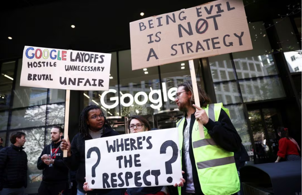 Google worker Shaquille and others hold signs, including a reference to the company's "Don't be evil" code of conduct phrase, at a demonstration against alleged union busting and layoffs risk outside the Kings Cross headquarters in London, Britain, April 4, 2023. REUTERS/Henry Nicholls
